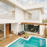 Contemporary interior of lounge area with swimming pool located on terrace of luxury villa in sunny day